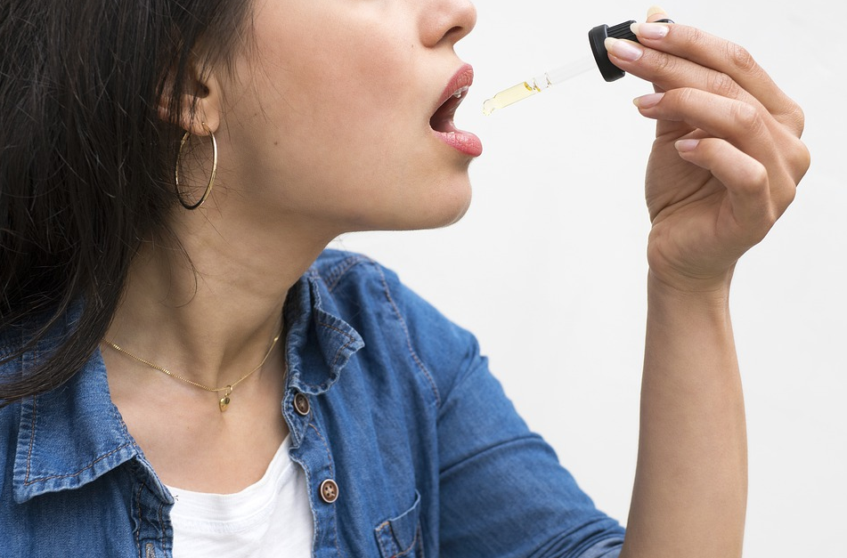 woman taking CBD oil